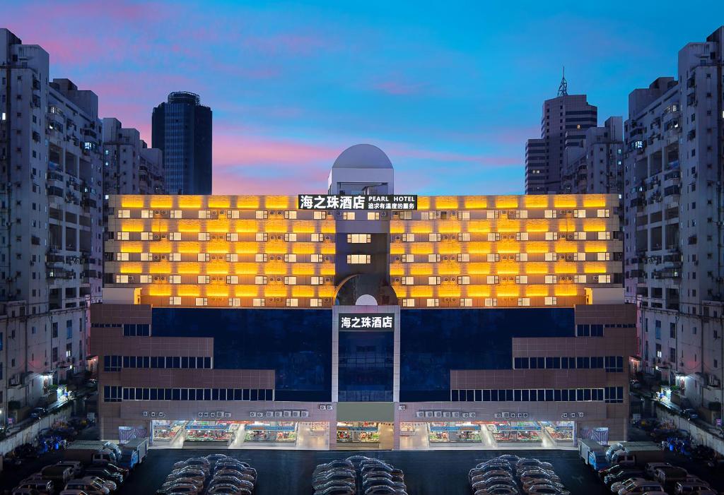 een groot gebouw met een gele gevel in een stad bij Pearl Hotel - Gongbei Port Zhuhai in Zhuhai