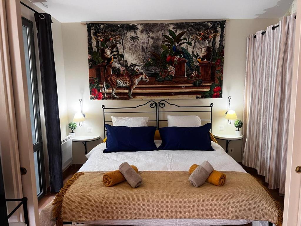 une chambre avec un grand lit avec des oreillers bleus dans l'établissement La Calade, à LʼIsle-sur-la-Sorgue