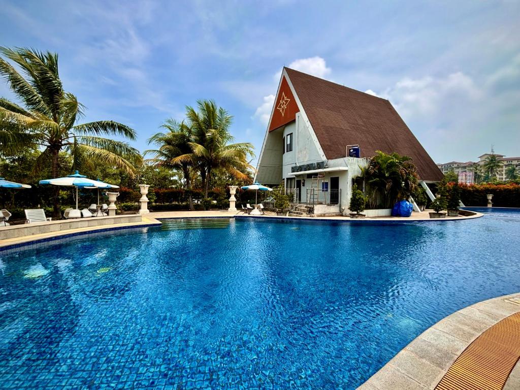a large swimming pool in front of a resort at Nemuru Villa Ubud Anyer in Anyer