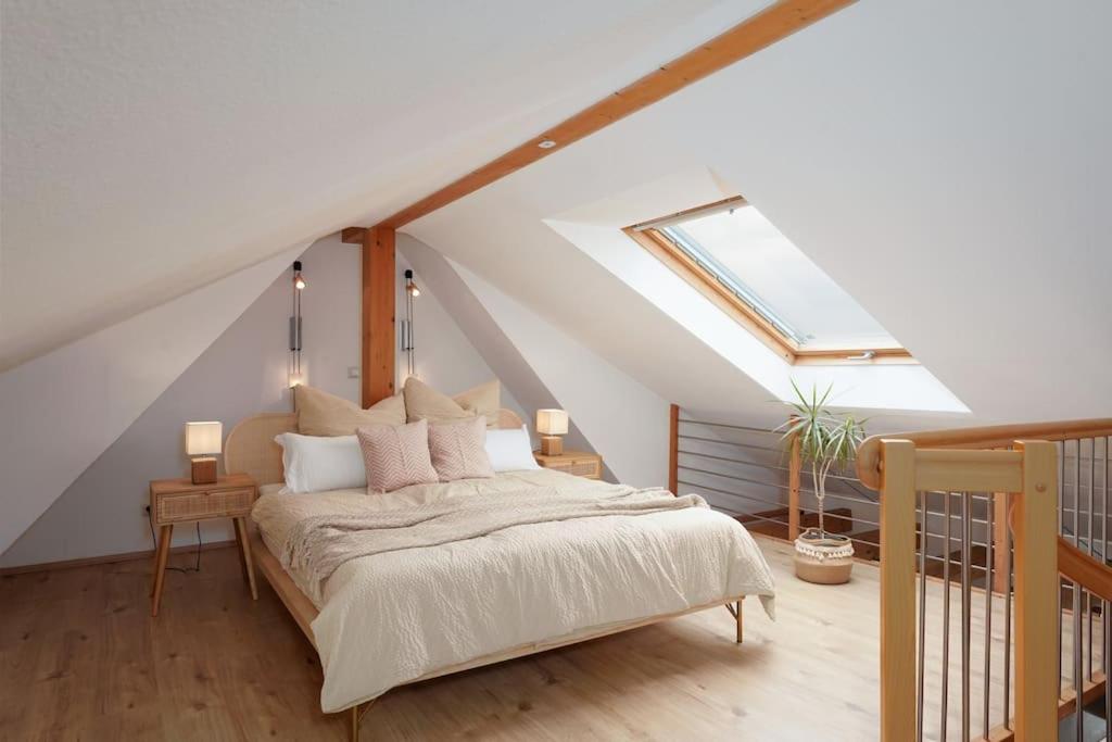 - une chambre avec un lit et une lucarne dans l'établissement Boho Apartment für 4 Wunderschöne Dachterrasse, à Eppelheim