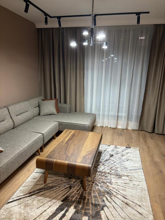 uma sala de estar com um sofá e uma mesa de centro em Sofia Apartment em Sófia