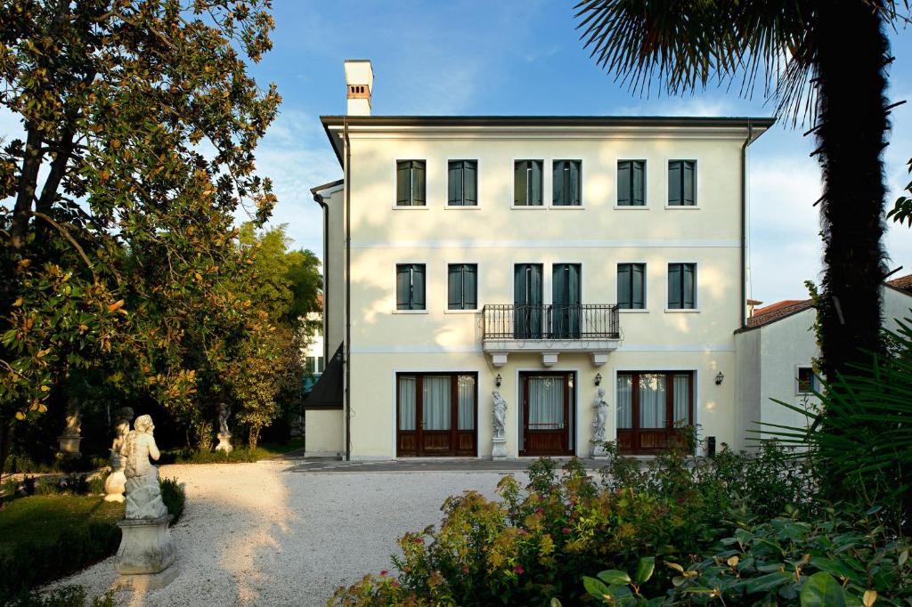 uma grande casa branca com uma varanda em cima em Villa Pace Park Hotel Bolognese em Preganziol