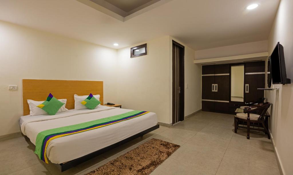 Treebo Trend Royal Palace, New Delhi في نيودلهي: غرفه فندقيه سرير وتلفزيون
