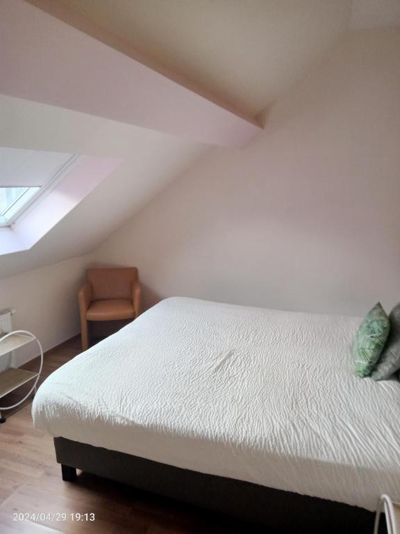 a bedroom with a white bed and a chair at Antwerpen OLIVIA Apartments in Antwerp
