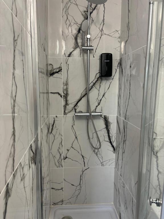 a bathroom with a shower with black and white marble at Hôtel de La gare-Les Floralies in Poitiers
