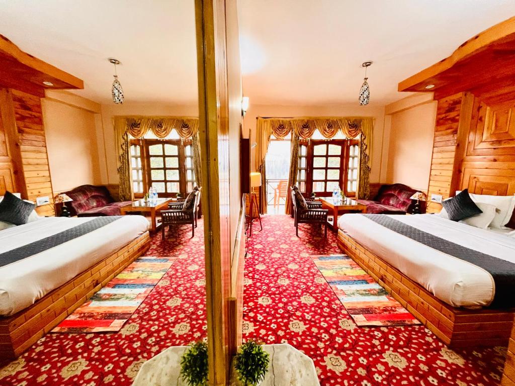 Habitación de hotel con 2 camas y alfombra roja en santoshi Lodge, en Zirakpur