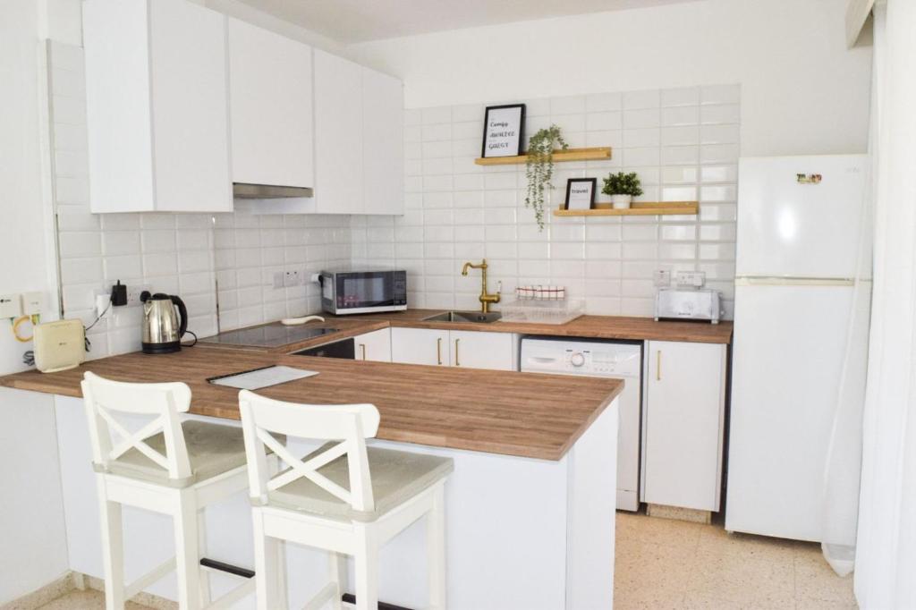 a kitchen with white appliances and a wooden counter top at Yiallos Village Apt. A101 in Meneou