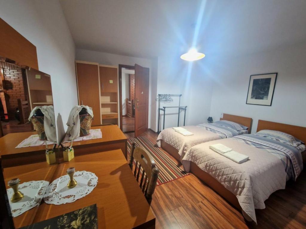 a bedroom with two beds and a table and a dining room at Hostel-F in Gjakove