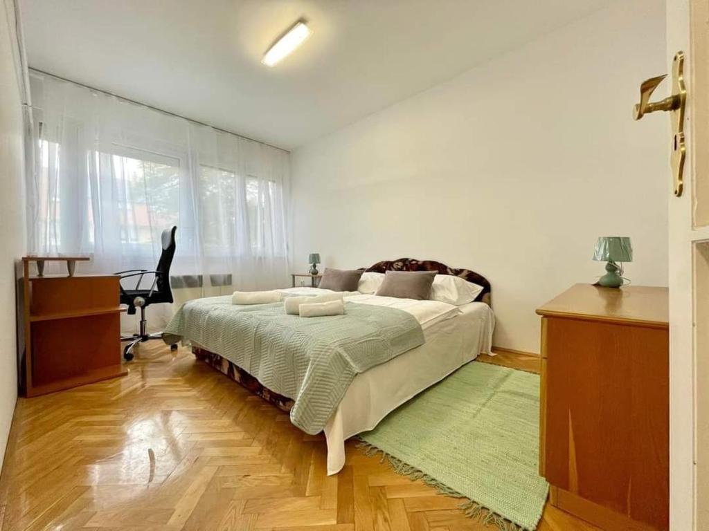ein Schlafzimmer mit einem großen Bett mit einem grünen Teppich in der Unterkunft Pipacs Apartman in Szeged