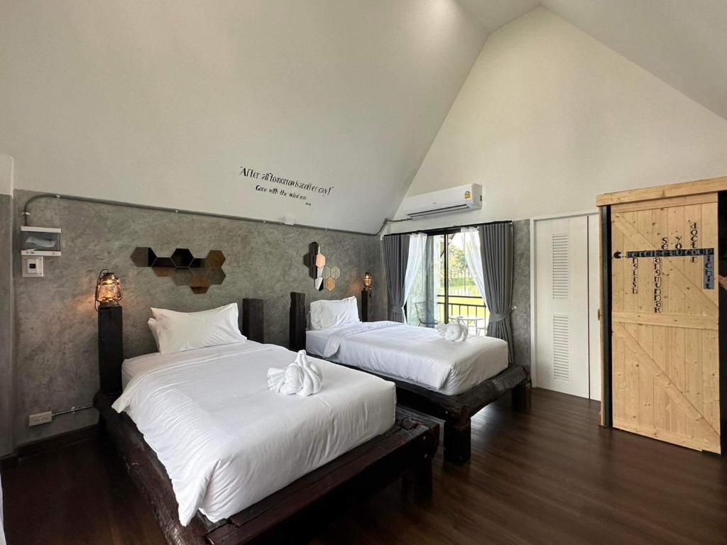 a bedroom with two beds with white sheets at 385 Homestay & Lake camp in Ban Khai Nao (1)
