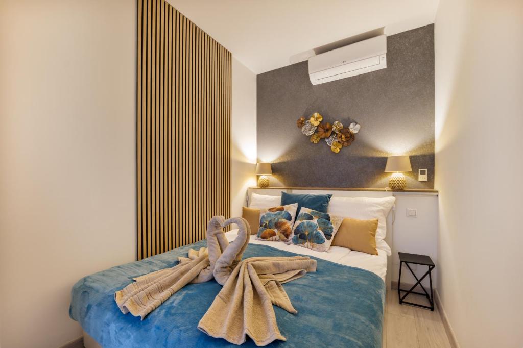 Rames-Cosmo Downtown Apartment with rooftop POOL في بودابست: غرفة نوم بها سرير مع مناشف عليه