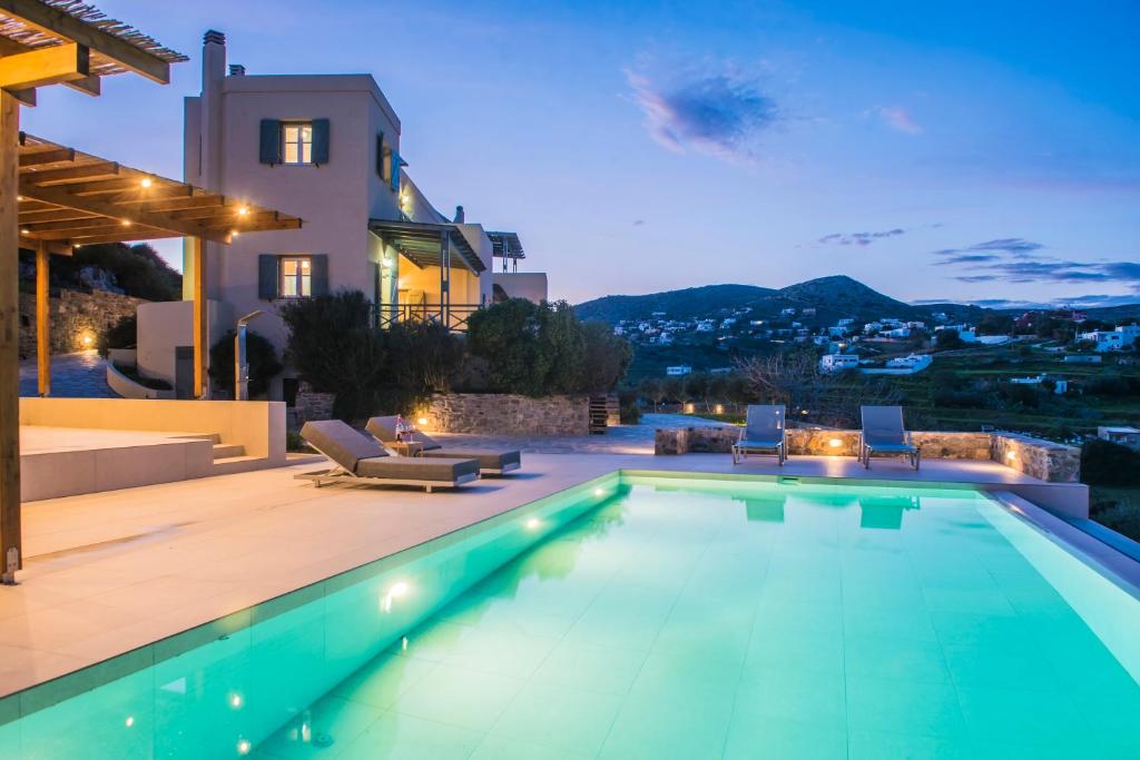 a villa with a swimming pool and a house at Avrofilito Syros Houses in Ermoupoli