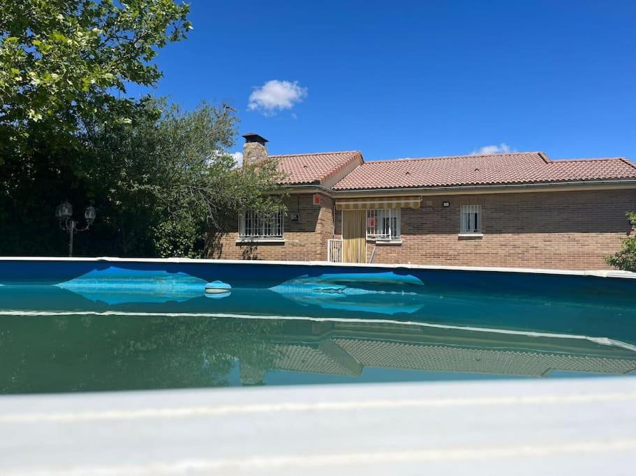 une piscine d'eau en face d'une maison dans l'établissement Casa con jardín en Escalona, à Escalona