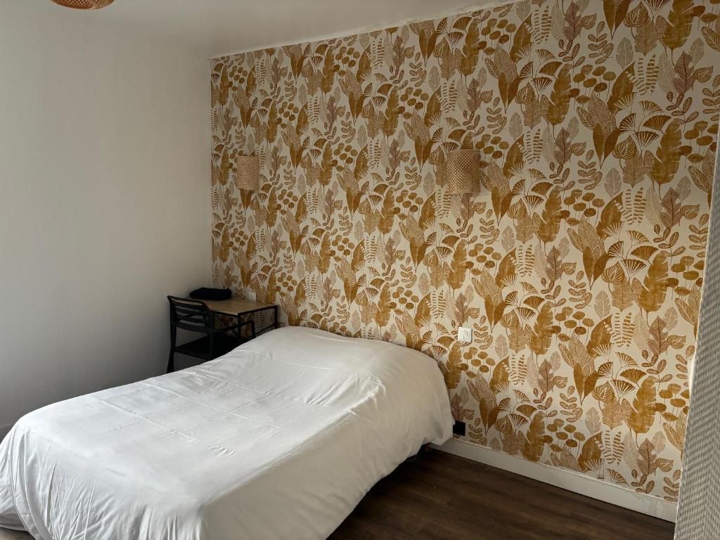 a bedroom with a bed and a wall with a wallpaper at Hôtel de La gare-Les Floralies in Poitiers
