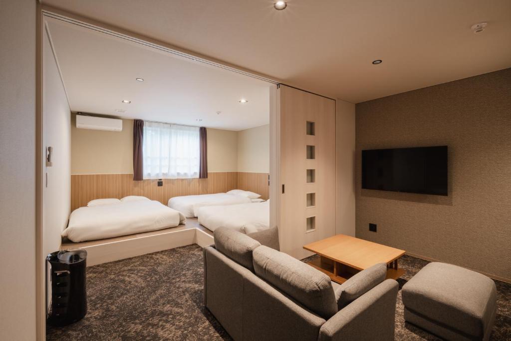 Habitación de hotel con 2 camas y TV de pantalla plana. en Hotel Ninestates Kagoshima, en Kagoshima