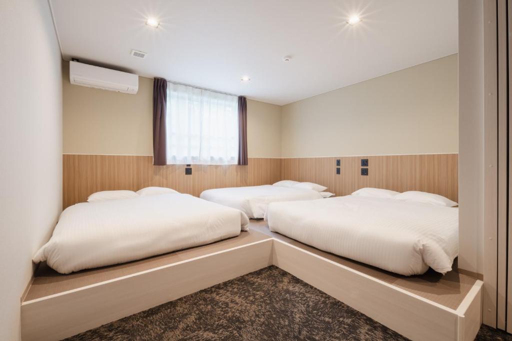Postel nebo postele na pokoji v ubytování Hotel Ninestates Kagoshima