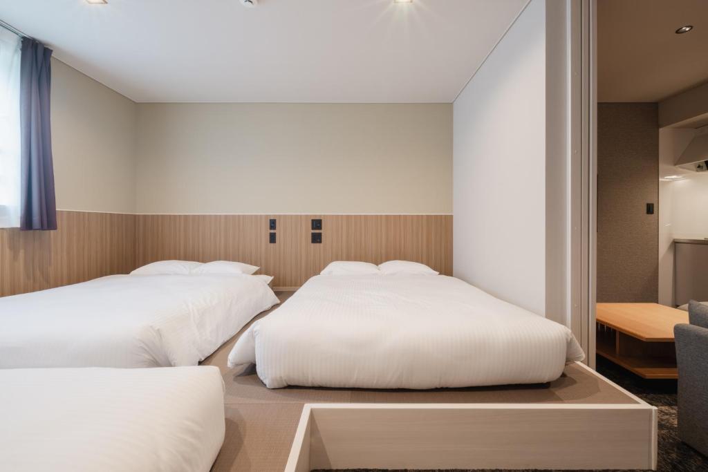 Postel nebo postele na pokoji v ubytování Hotel Ninestates Kagoshima