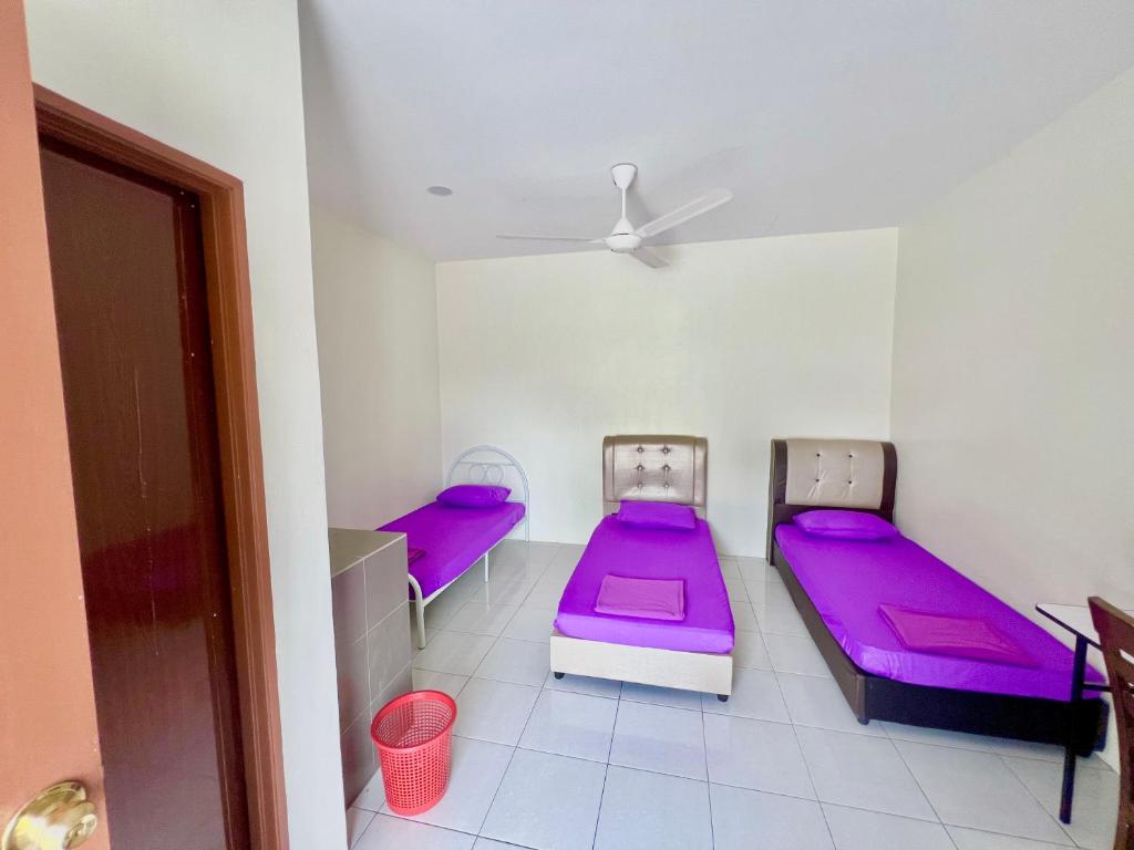 2 camas en una habitación con colchones morados en Roomstay Ehsan, en Pekan