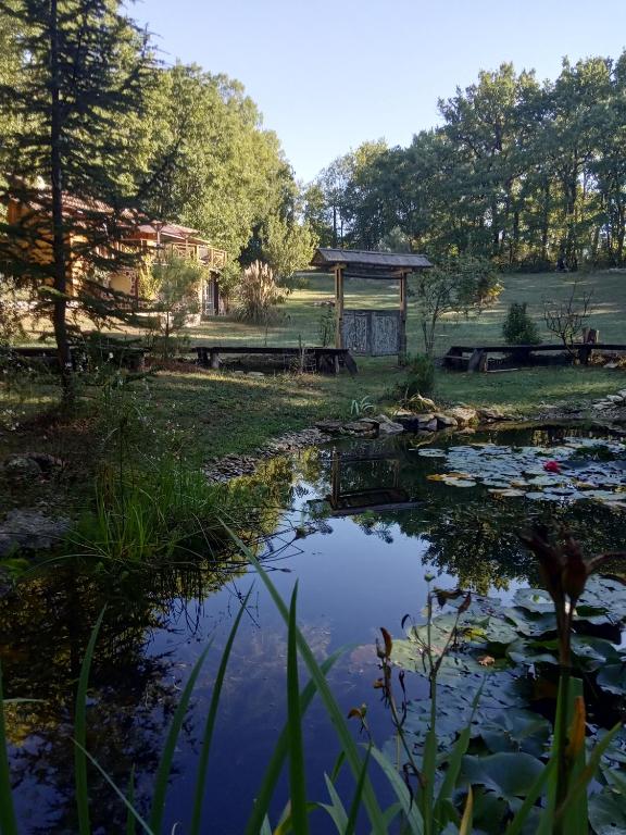 a pond with a gazebo in a yard at Echappée sauvage in Masquières