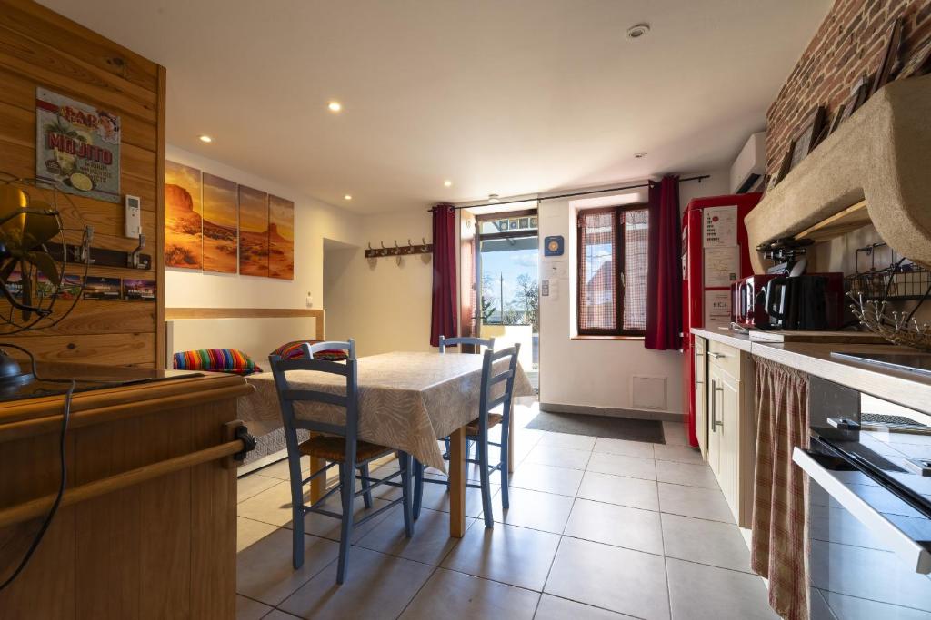 a kitchen with a table and chairs in a kitchen at Gite du Moulin in Saint-Laurent-dʼAndenay