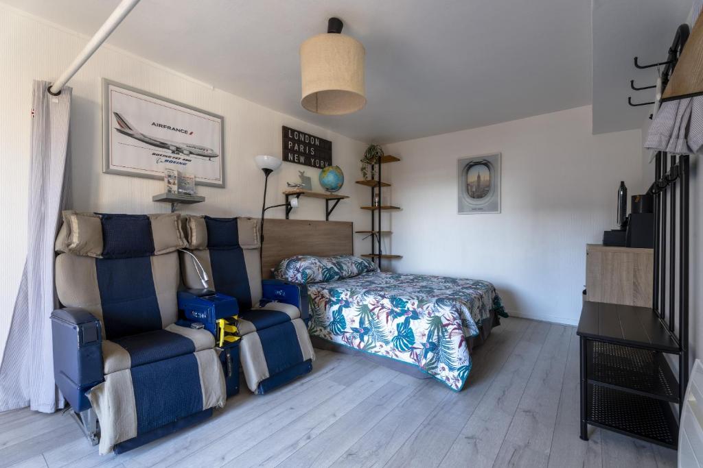 a bedroom with a bed and a couch and a chair at Gite du Moulin in Saint-Laurent-dʼAndenay