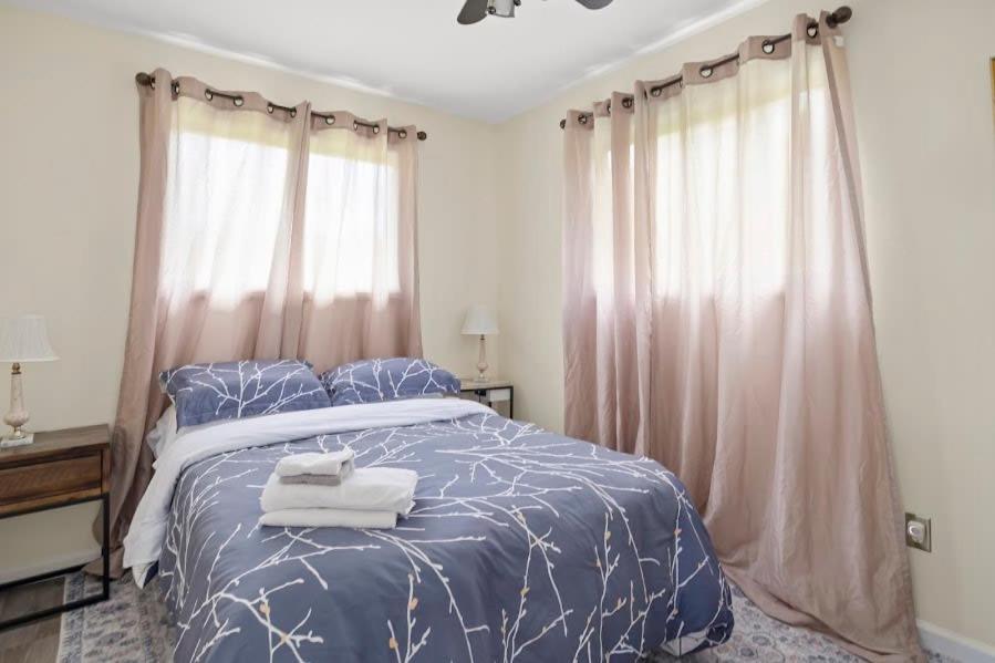 um quarto com uma cama azul com toalhas em Relaxing 2BR Lakehouse by CozySuites em Copake