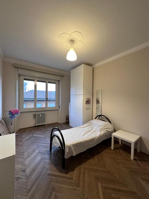 布雷西亞的住宿－Room Via Solferino 17 Brescia，一间卧室配有一张床、一张桌子和一个窗户。
