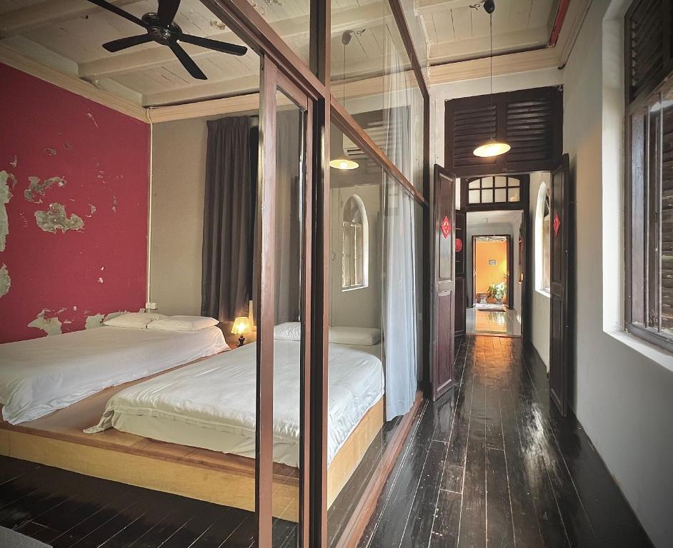 due letti in una stanza con pareti rosse di CHCH by LEJU a Malacca