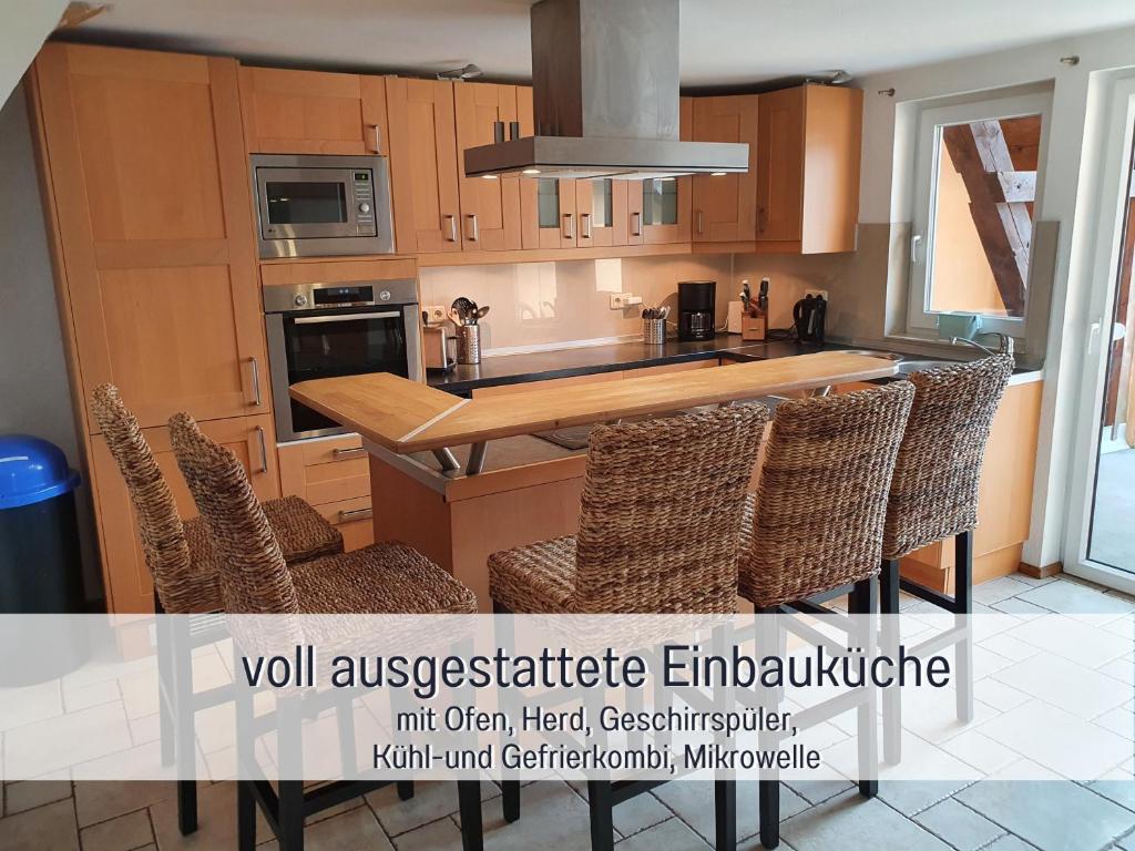 - une cuisine avec des placards en bois, une table et des chaises dans l'établissement Möbliertes Haus in Nauen H1, à Nauen