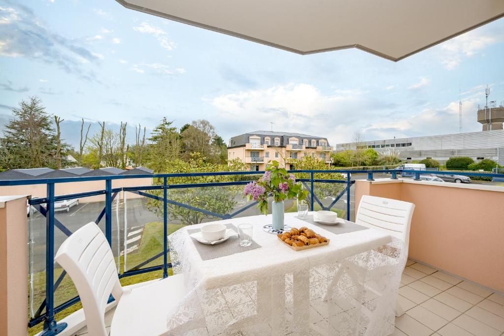 een witte tafel en stoelen op een balkon met uitzicht bij Noz Vat - Appt pour 2 avec balcon in Plouha