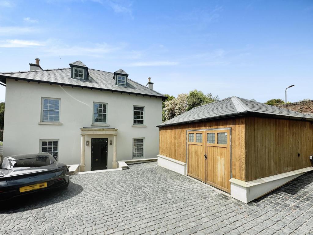 een huis met een garage en een auto voor de deur bij 5 Bed Luxury House with Swimming pool in Chepstow