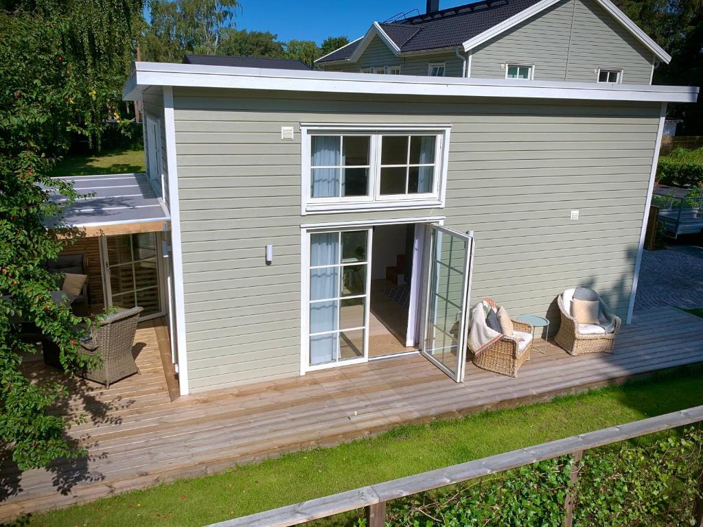 a house with a deck with two chairs on it at Strandnära, pergola, P-plats i Höllviken in Höllviken