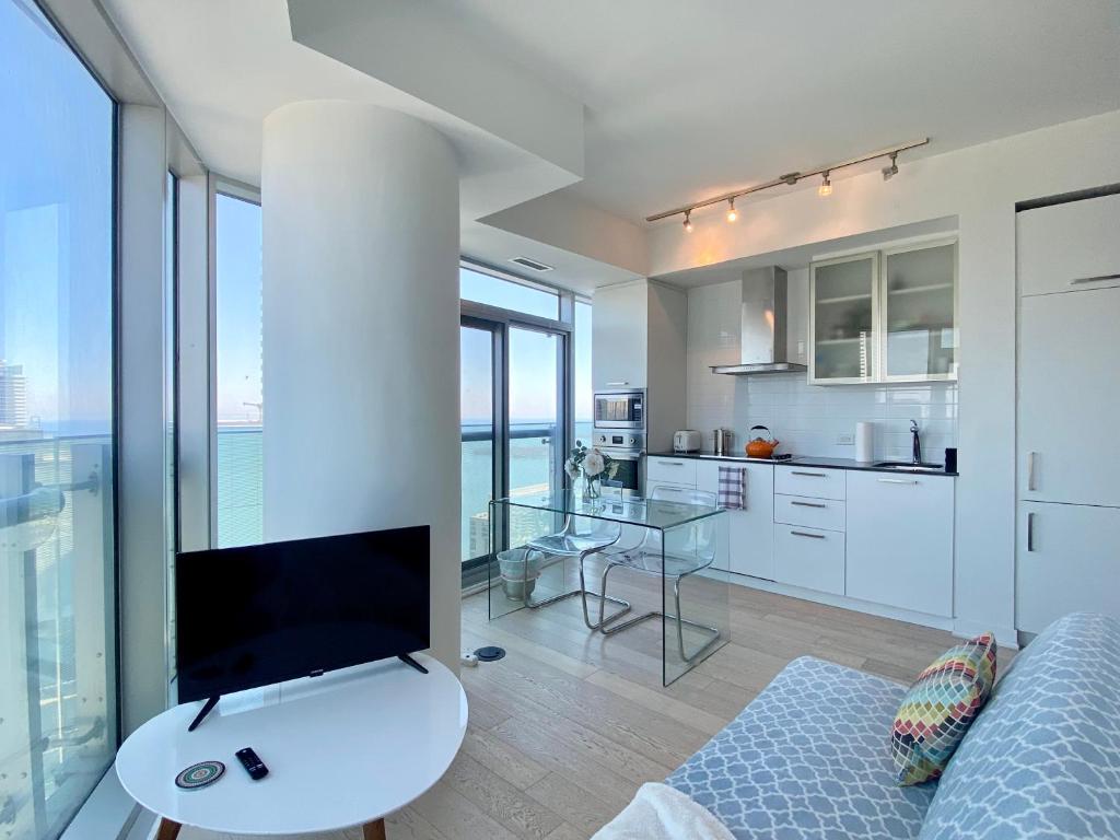 uma sala de estar com uma televisão, um sofá e uma cozinha em waterfront Executive INN em Toronto