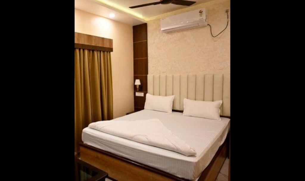 a bedroom with a bed with white sheets at FabHotel Granotel in kolkata