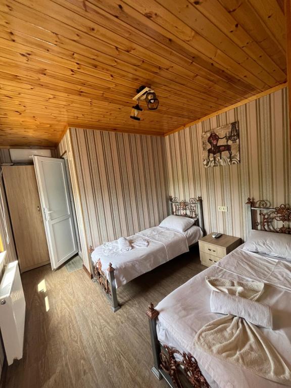 um quarto com 2 camas e um tecto de madeira em Riverside Tekhuri em Martvili