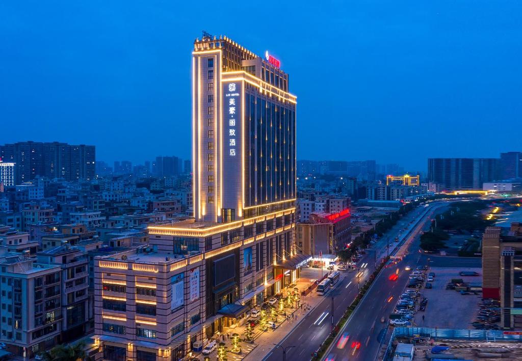 um edifício iluminado numa cidade à noite em Liz Hotel Maoming Dianbai em Maoming
