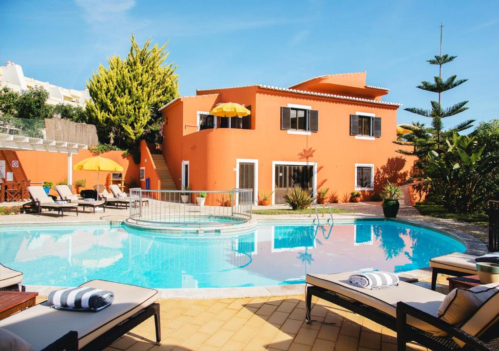 a villa with a swimming pool in front of a house at Villa Mar Azul in Lagos