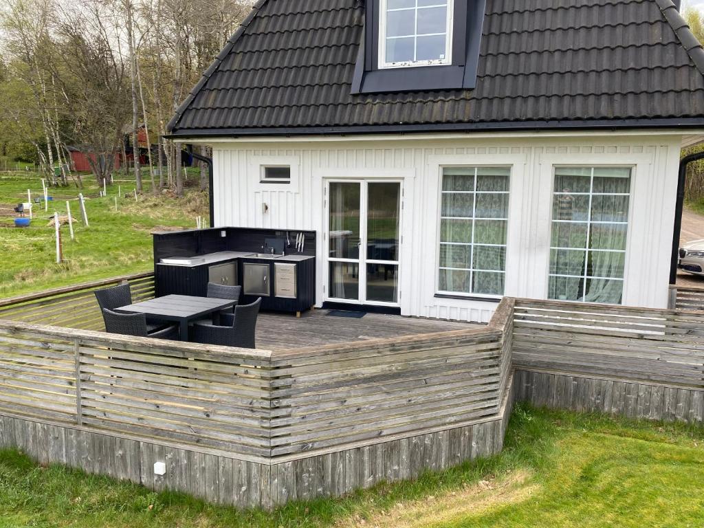 a backyard deck with a table and a stove at Skedala horsefarm in Halmstad