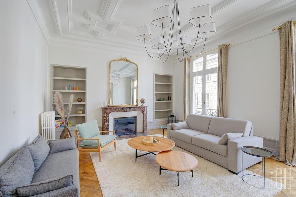 - un salon avec un canapé, une table et un lustre dans l'établissement L'albizia / Halles De Tours, à Tours