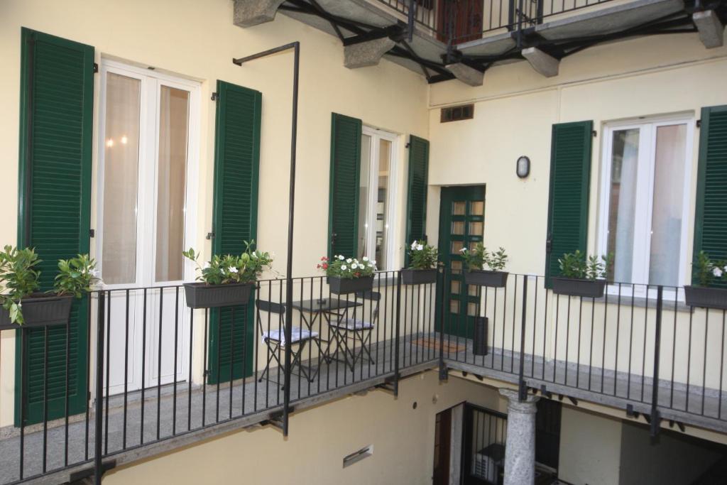 ein Balkon eines Gebäudes mit grünen Fensterläden und einem Tisch in der Unterkunft JB in Como in Como