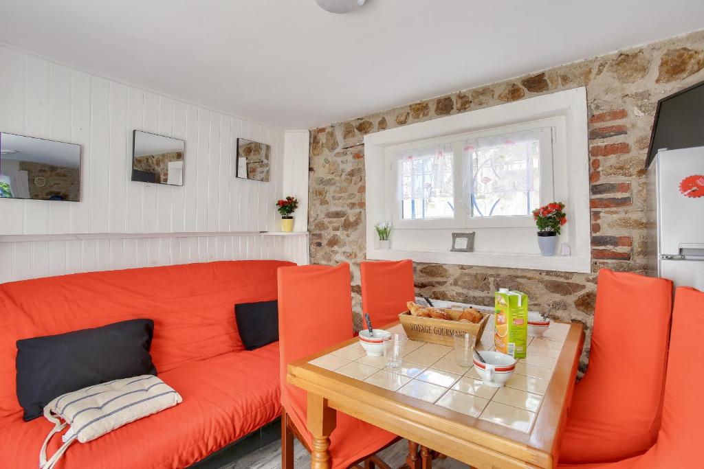 un salon avec un canapé orange et une table dans l'établissement Escale à deux pas de la plage du Val André, à Pléneuf-Val-André
