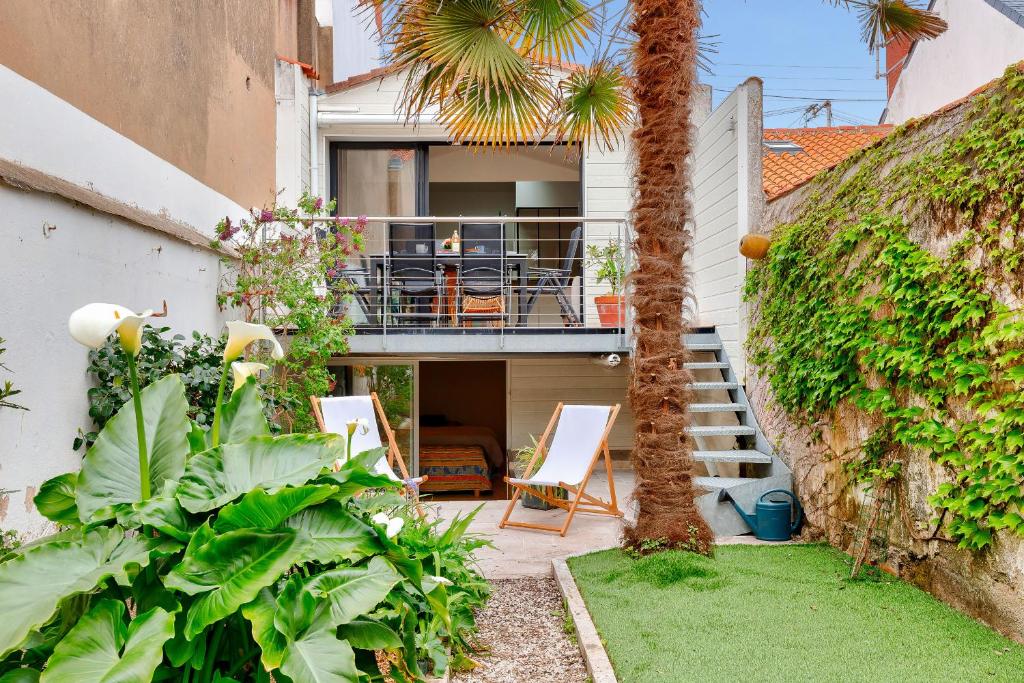 une maison avec un balcon et un palmier dans l'établissement 400m de la plage - maison avec jardin, à Les Sables-dʼOlonne