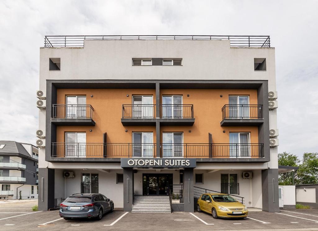 an apartment building with two cars parked in a parking lot at Otopeni Suites by CityBookings in Otopeni