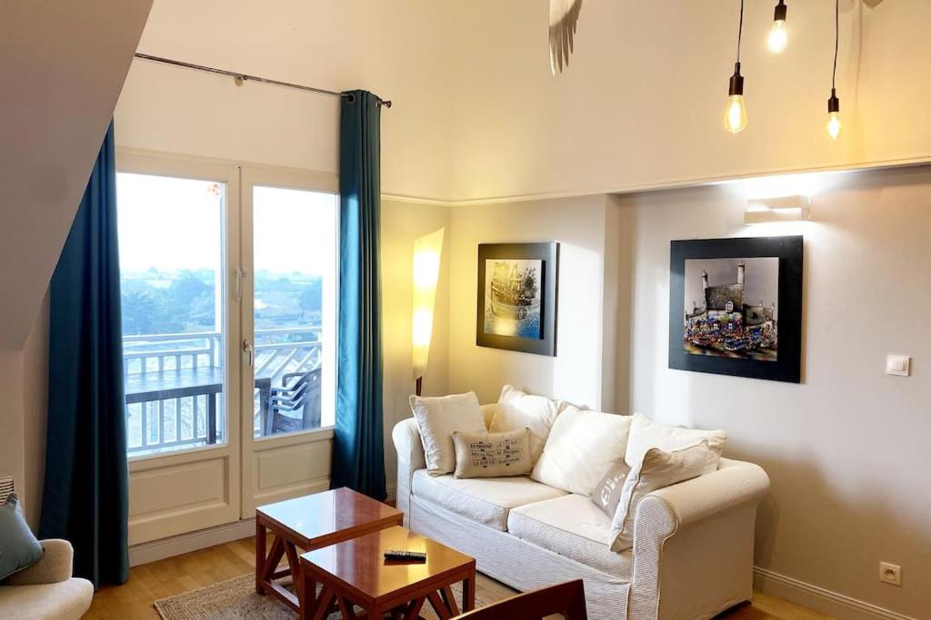 - un salon avec un canapé et une grande fenêtre dans l'établissement Magnifique appartement plein sud - Piscine, au Croisic