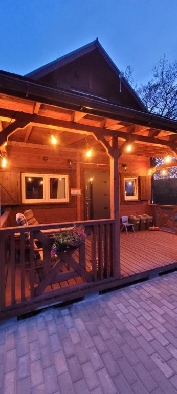 a wooden cabin with a deck at night at Kolej na sudety in Leszczyniec