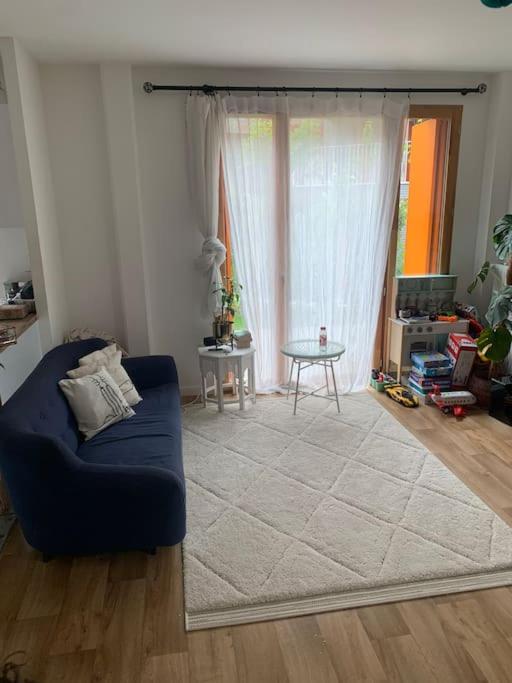 un salon avec un canapé bleu et une table dans l'établissement JO : Charmant appart proche de Paris, à LʼÎle-Saint-Denis
