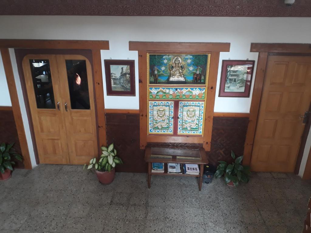 una habitación con puertas y un banco y una pintura en la pared en Dragon Hotel, en Pokhara