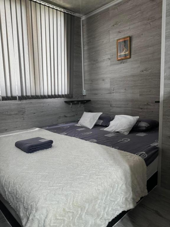 a large bed in a room with a large window at Apartment in Chişinău