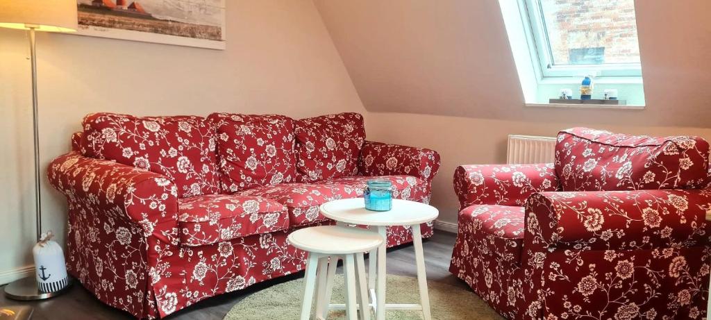 sala de estar con sofá rojo y mesa pequeña en Urlaub im Ostseebad Grömitz - Haus Neuborn - strandnah und ruhig gelegen Whg OG en Grömitz