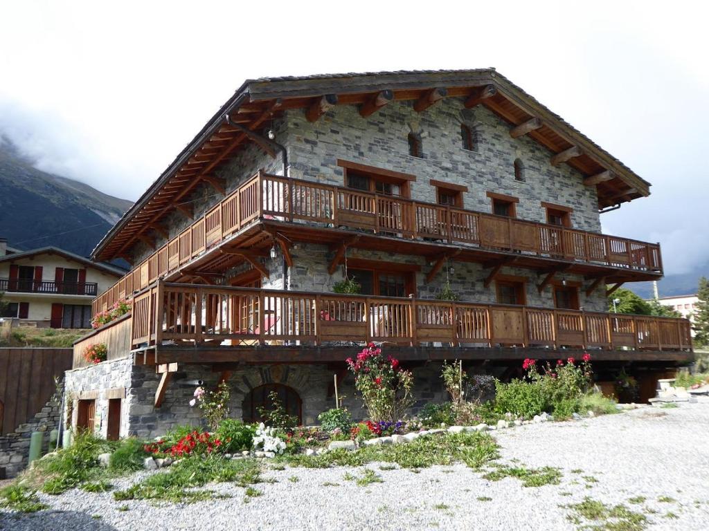 a building with a balcony on the side of it at Chalet Les Liouès in Sollières-Sardières